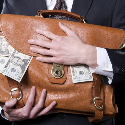Closeup,Of,Man,Holding,Briefcase,With,Money,Spilling,Out,Close