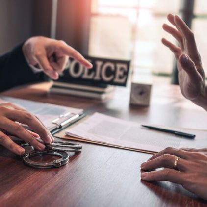 Suspect,With,Handcuffs,Being,Interviewed,In,Interrogation,Room,By,Police