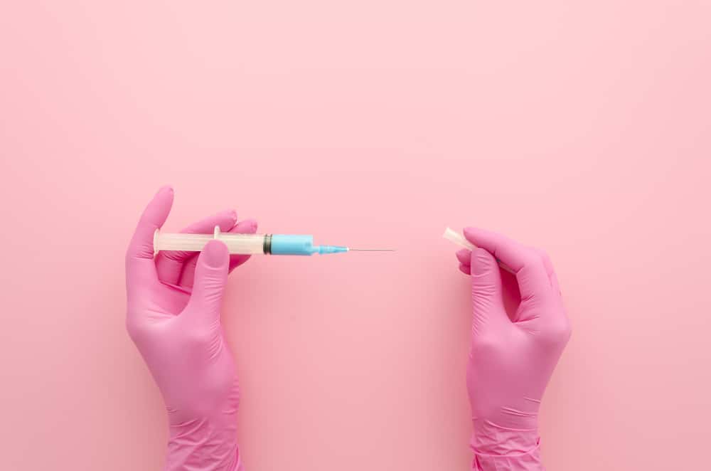 Pink gloves holding a syringe for B-12 injections in Coral Gables, FL